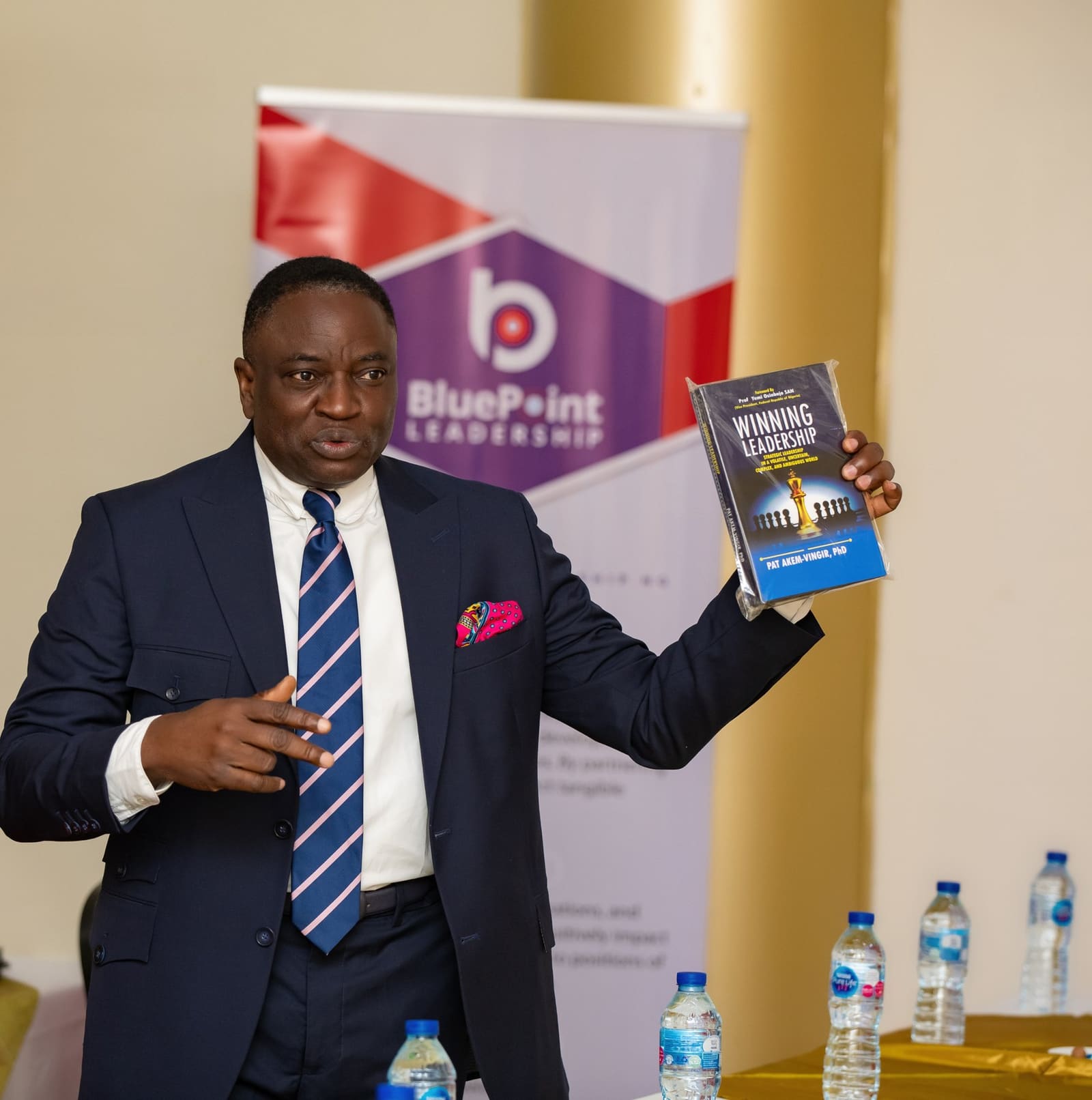 Pat Akem-Vingir holding up his book Winning Leadership